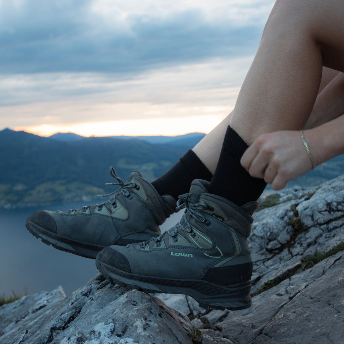 Lederwanderschuhe auf einem Felsen in der Abenddämmerung – Obermaterial, das regelmäßig imprägniert werden muss