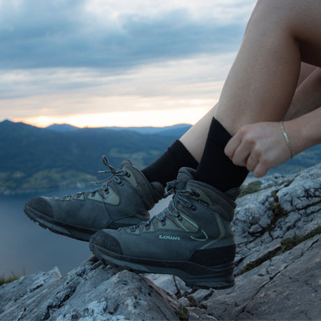 Lederwanderschuhe auf einem Felsen in der Abenddämmerung – Obermaterial, das regelmäßig imprägniert werden muss
